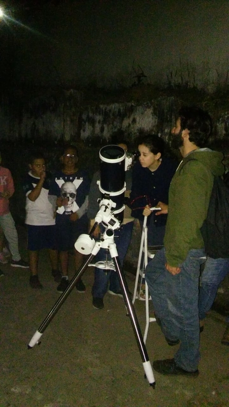 Criança observando o céu pelo telescópio de campo na escola Don Veloso